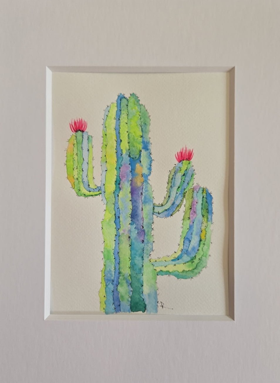 Watercolor of a colorful saguaro cactus with pink blooms in greens and blues by Roxanne Langley
